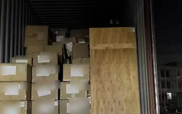 Cartons and a wooden crate loaded for origin transport in Shenzhen at night.