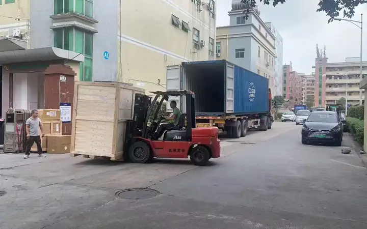 Forklift handling a wooden furniture crate beside an open container at the Zhejiang factory.